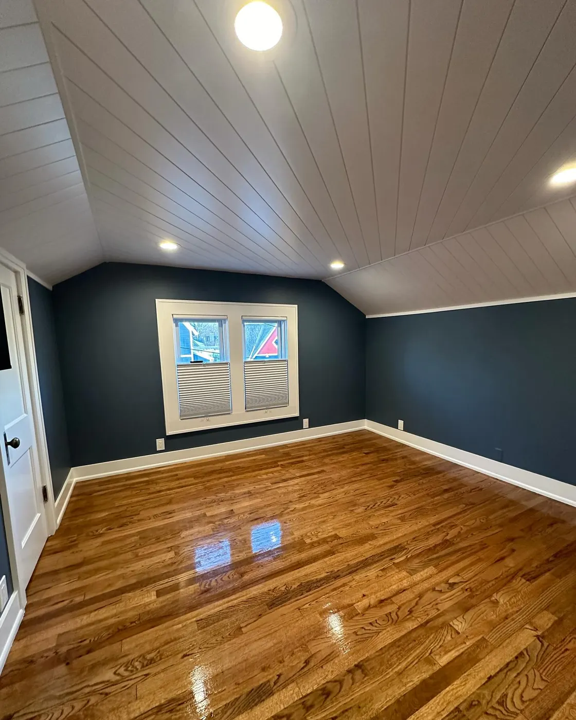 A freshly cleaned bedroom with polished hardwood floors